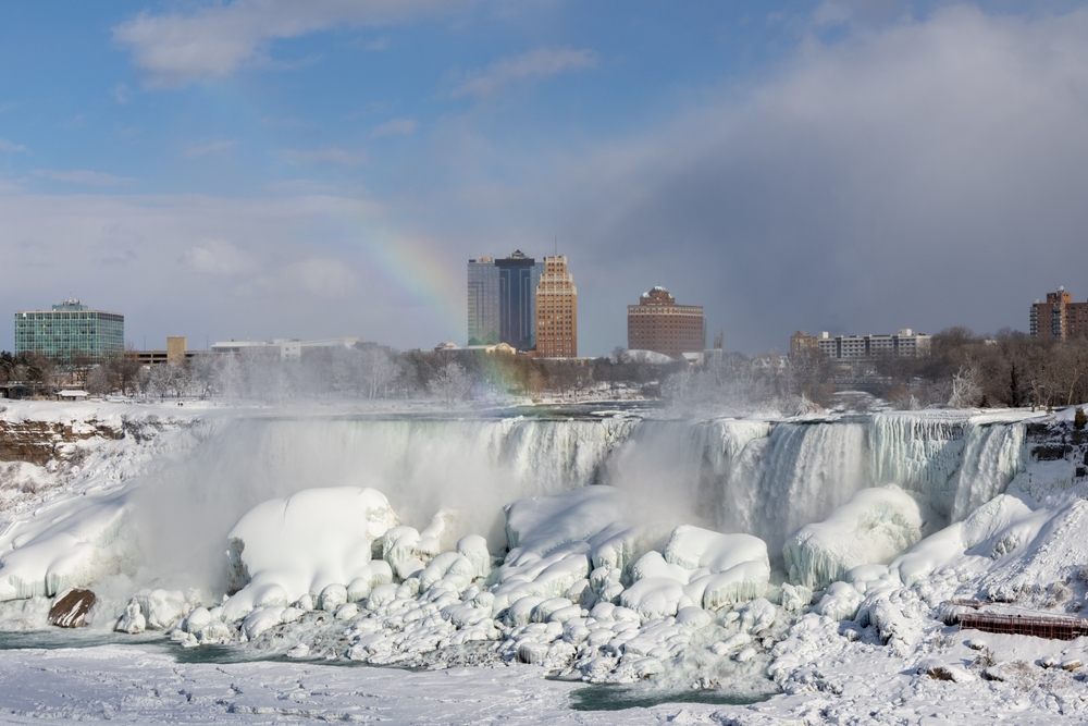 Niagara,Falls,With,A,Rainbow,In,Winter.,Frozen,Waterfall,With
