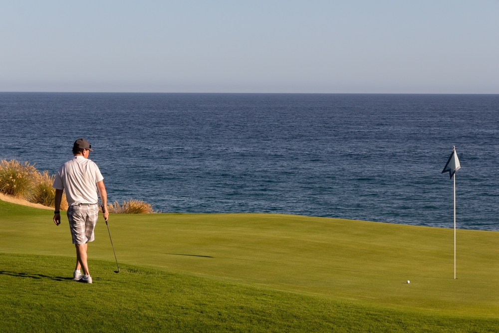 Putting,Green.,Adult,Man,Watching,As,Ball,Rolls,On,Golf