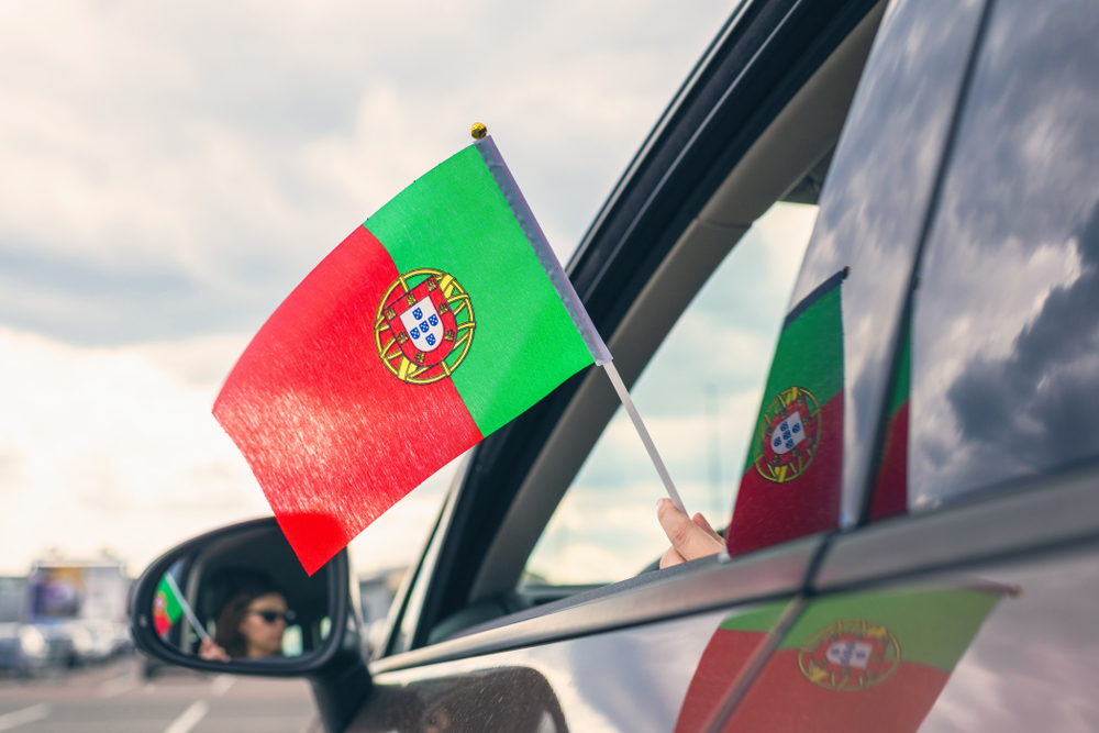 Woman,Or,Girl,Holding,Portuguese,Flag,From,The,Open,Car
